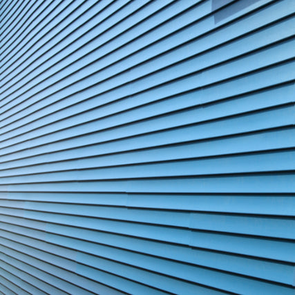 SidingBlue horizontal siding panels covering a wall, creating a symmetrical pattern. The clean lines and cool tone convey simplicity and modernity.